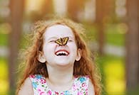 Kind mit Schmetterling auf der Nase